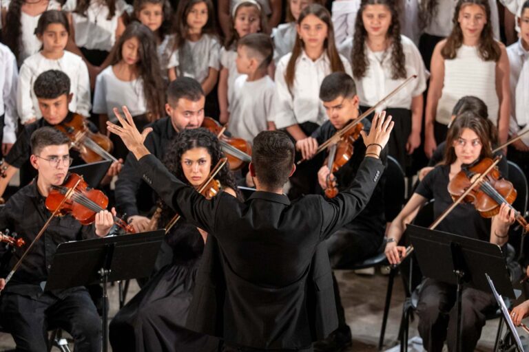 direttore di orchestra di spalle mentre dirige